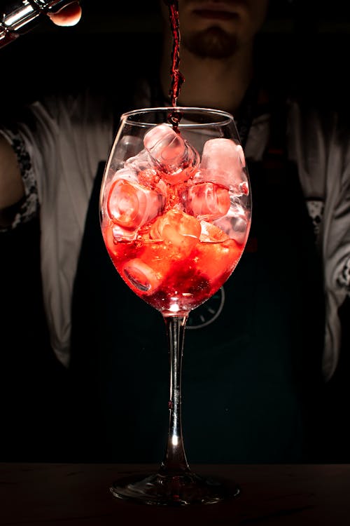 A Person Pouring Beverage in a Wine Glass