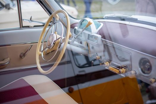 Interior view of a vintage car showcasing a classic steering wheel and retro dashboard design.