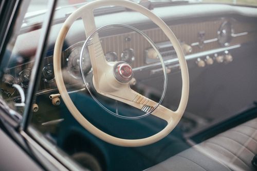 Free Close-up of a vintage car dashboard showcasing a classic steering wheel and interior details. Stock Photo
