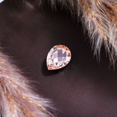 Faceted pear-cut gemstone on dark satin — photo by The Glorious Studio on Pexels