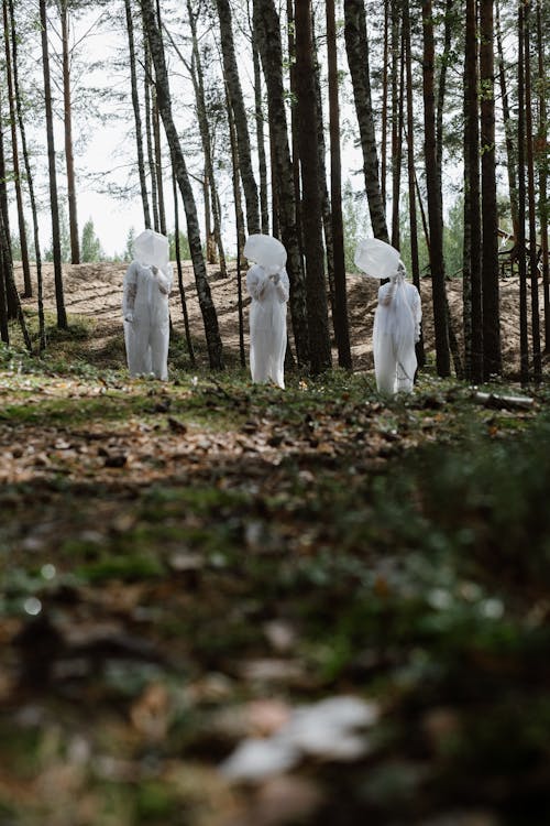 Man and Woman in White Wedding Dress Walking on Forest