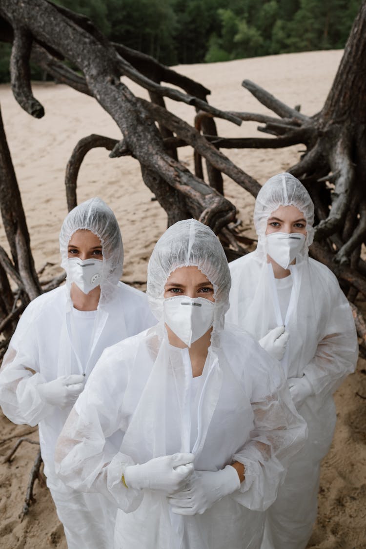 High-Angle Shot Of Three People Wearing White Hazmat Suits