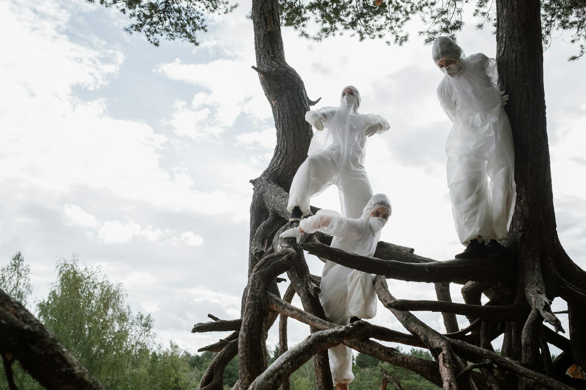 People Wearing Protective Suit Posing on Tree Roots