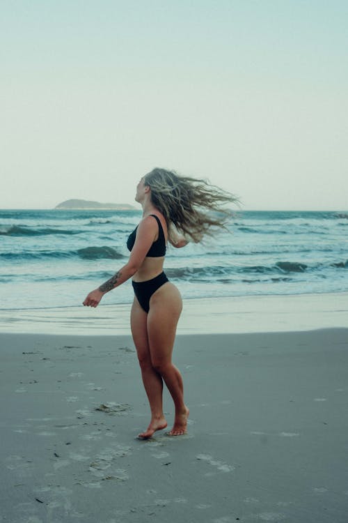 Woman in Black Bikini With Flying Hair on Beach 