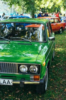 A classic green car displayed at an outdoor vintage car show.