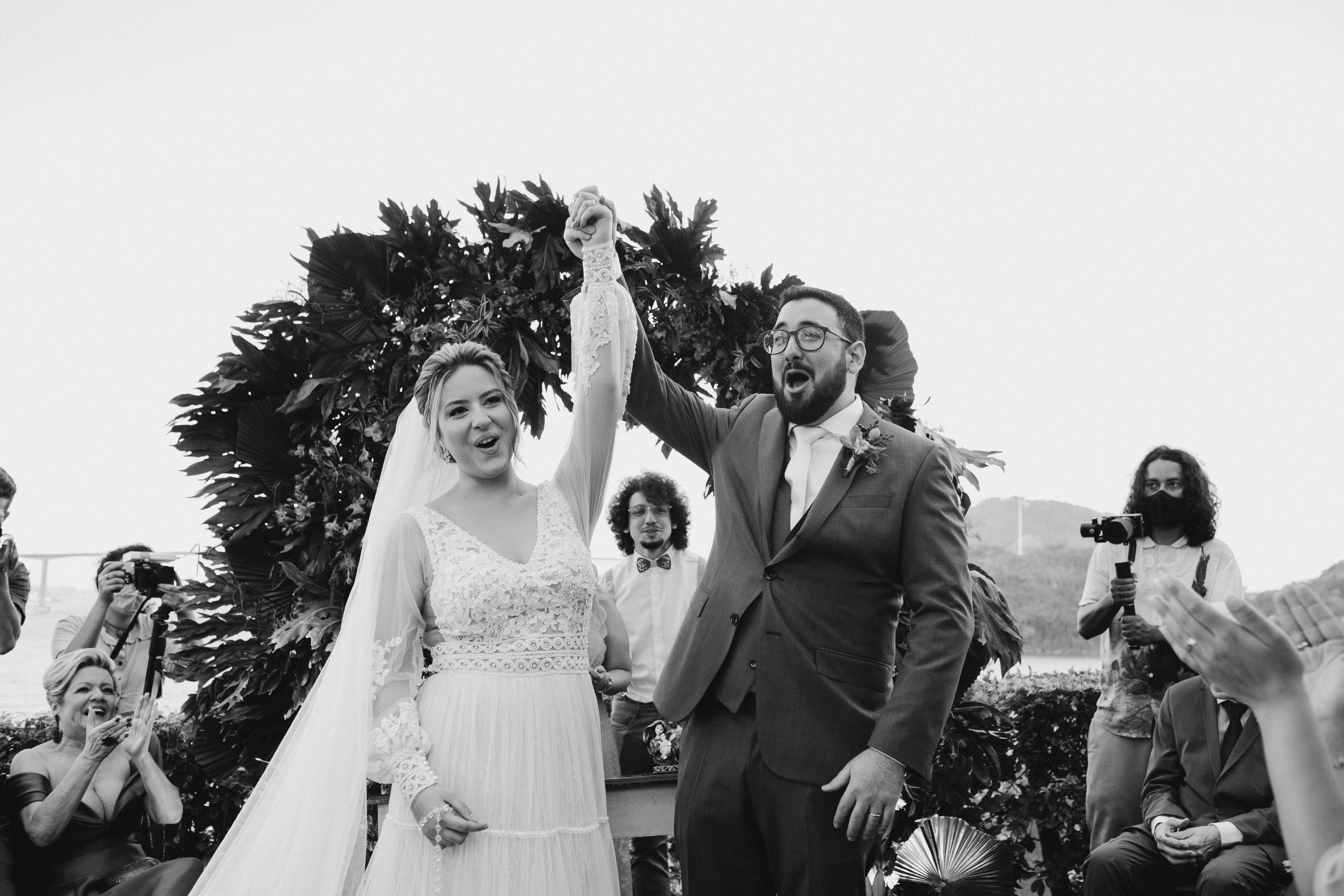 A happy couple celebrates their wedding outdoors with friends and family.