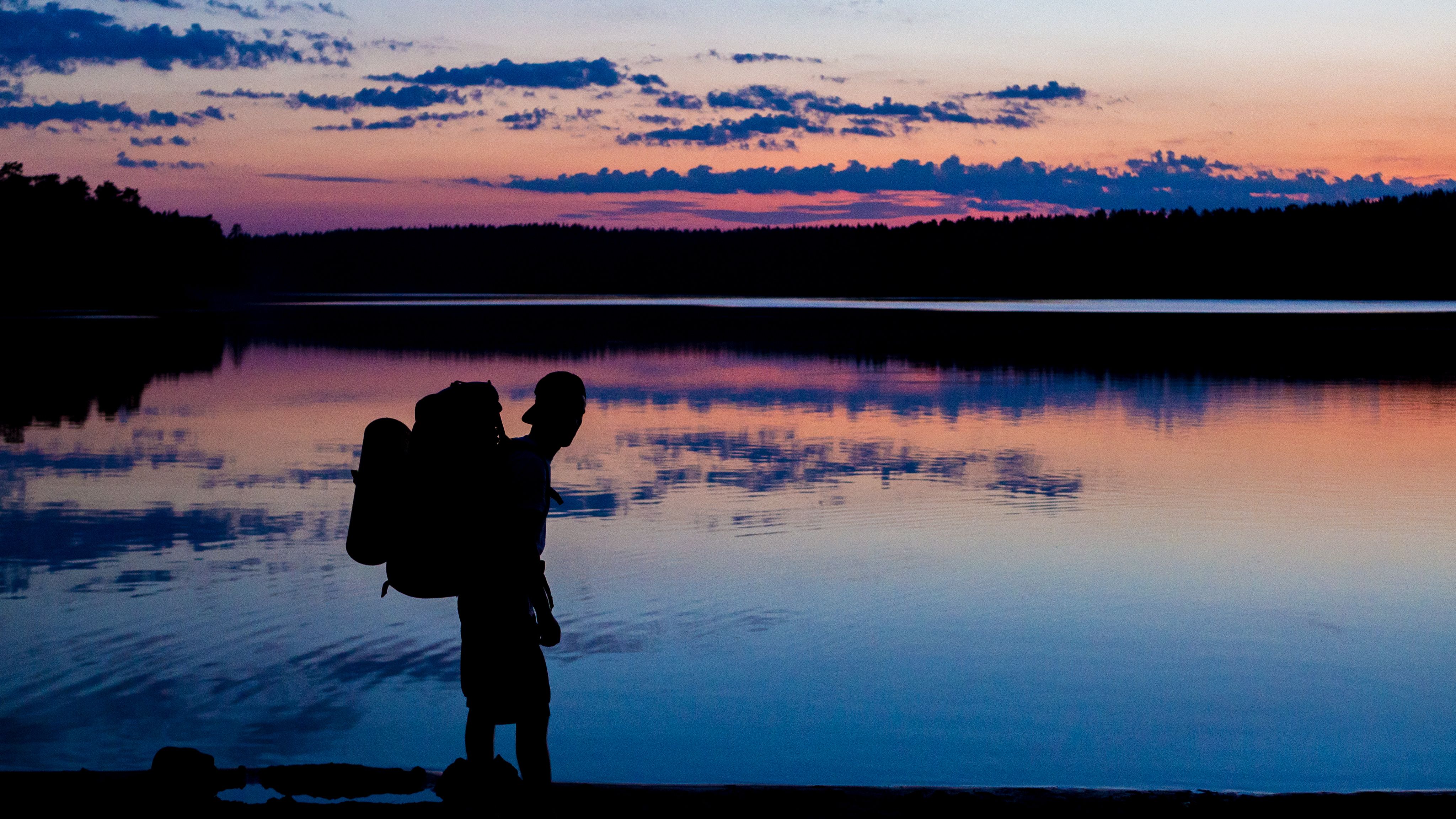 Silhouette of Man Near Body of Water during Sunset · Free Stock Photo