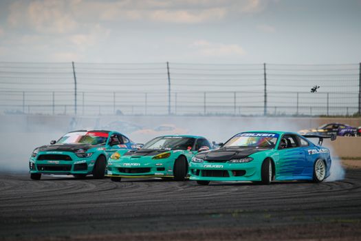 Exciting drift action featuring cars with Falken Tyres livery at a racing circuit.