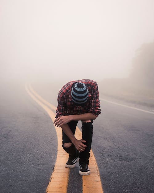 Man Wearing Red Plaid Shirt Standing in Center Road