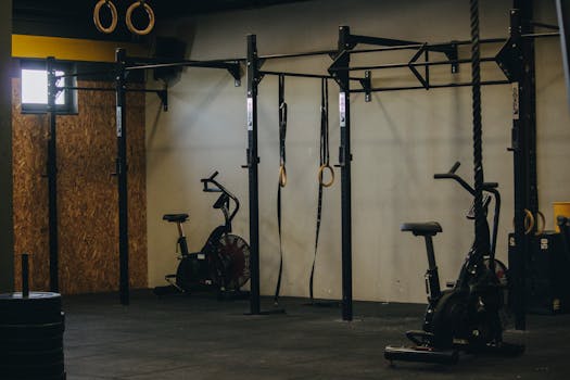 Industrial-style gym with exercise bikes, rings, and pull-up bars in Angola.