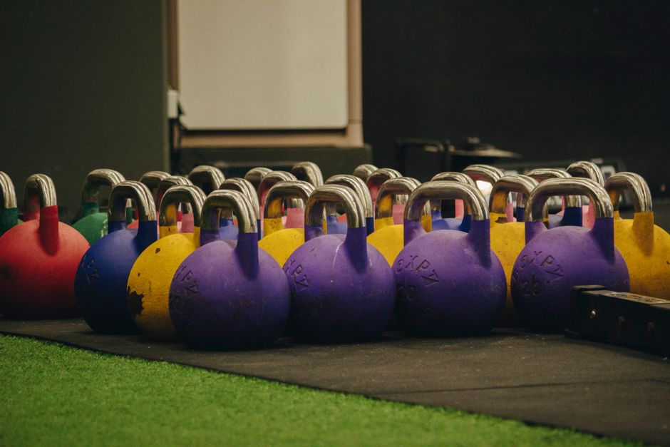Vibrant kettlebells neatly arranged on the gym floor, ready for workout sessions.