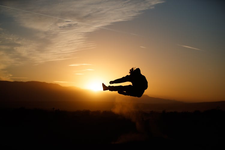 Silhouette Of A Person Jumping During Sunset