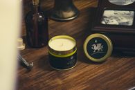 Cozy scented candle setting with Welsh branding on a wooden surface.