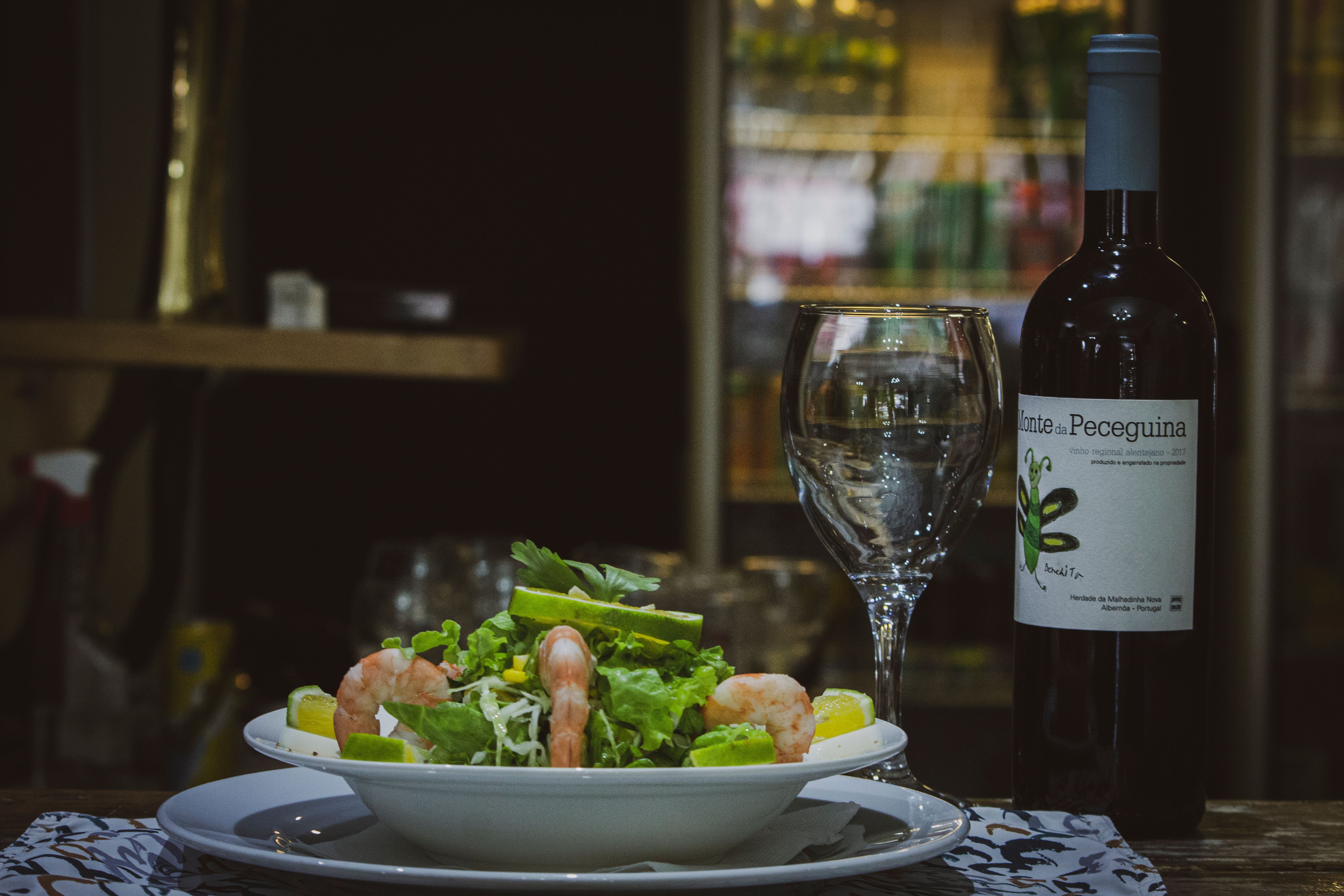 Indulgent shrimp salad paired with wine; indoor Angolan ambiance.
