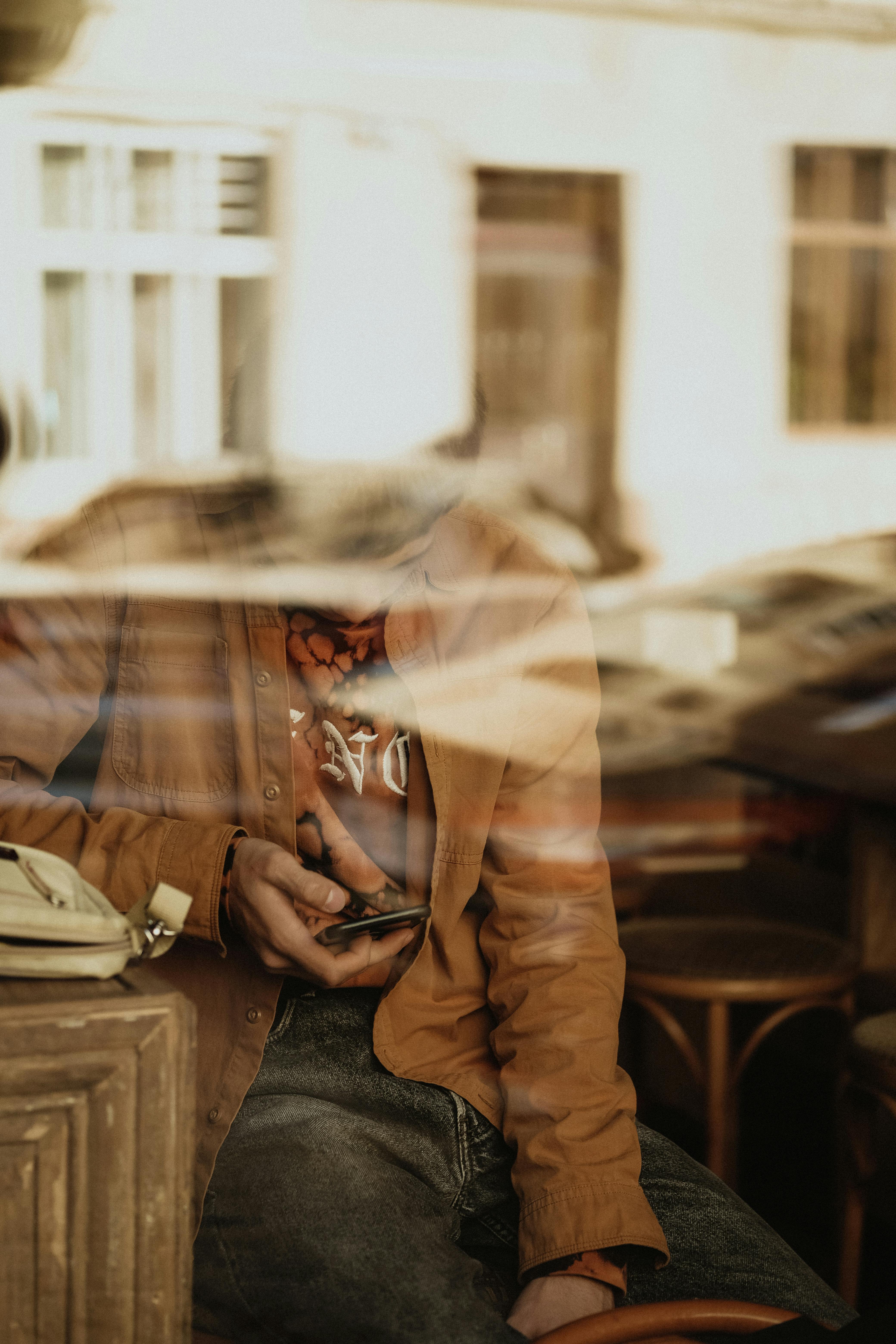 unrecognizable man sitting in cafe with smartphone