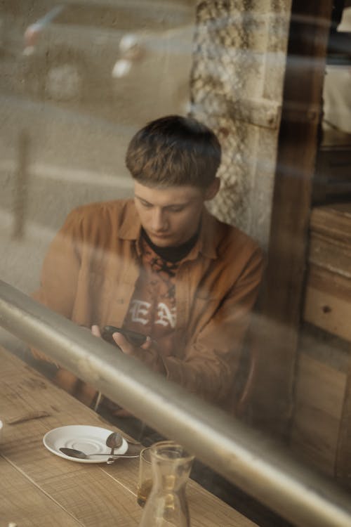 Free Focused young man sitting at table in cafe Stock Photo