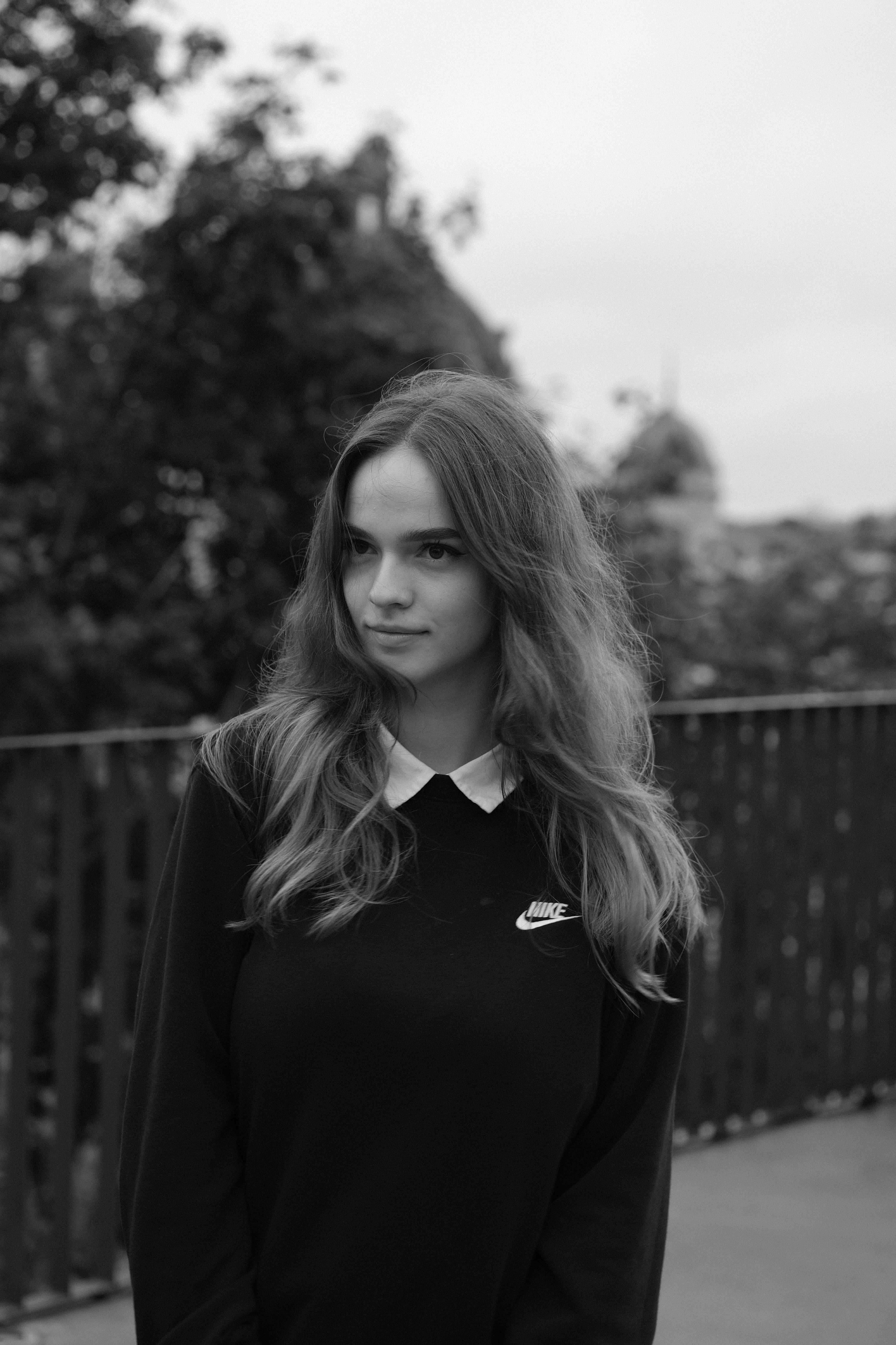 Monochrome portrait of a caucasian teenage girl with a serene expression, outdoors.
