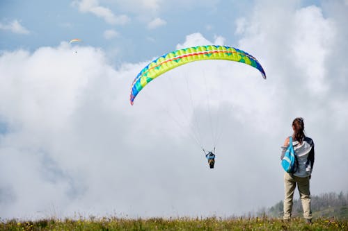 Person Paragliding on a Cloudy Sky