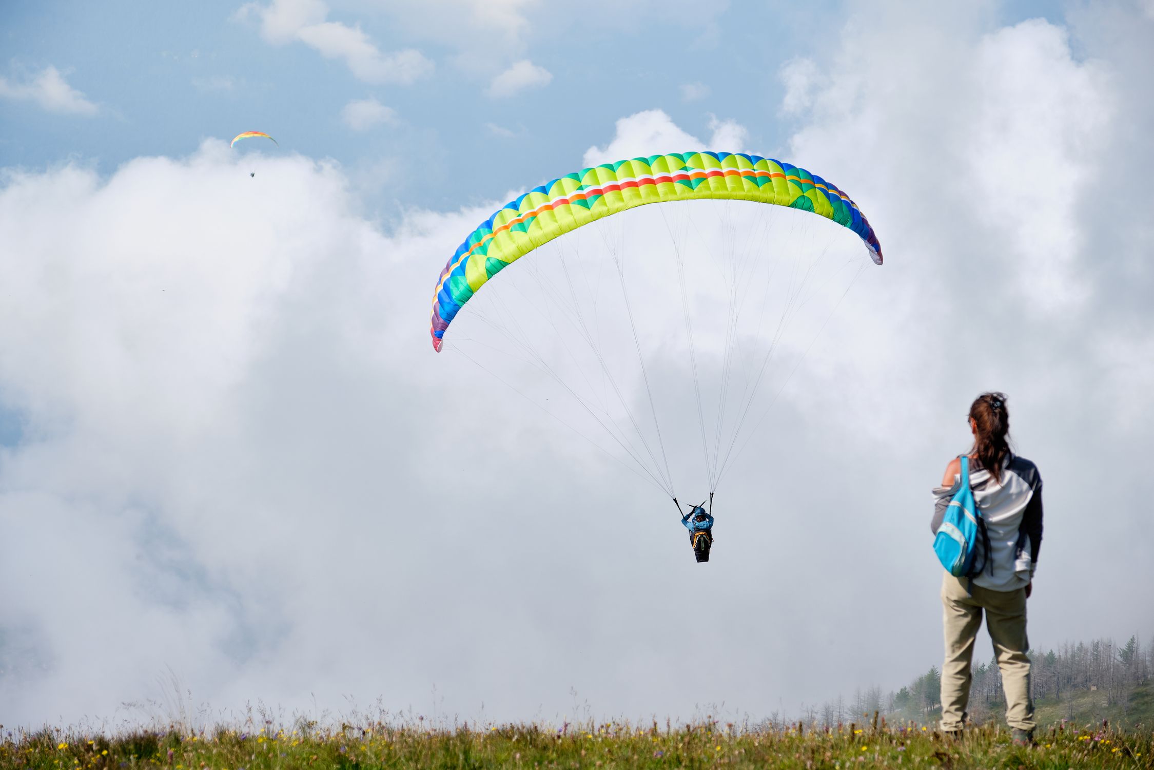 Colorful paragliding parachute against a dramatic cloudy sky Colorful paragliding parachute against a dramatic cloudy sky