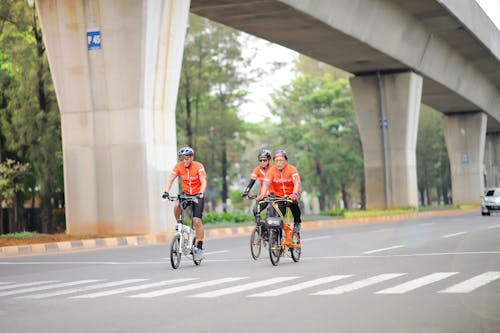 Three People Riding Bicycles on the Road