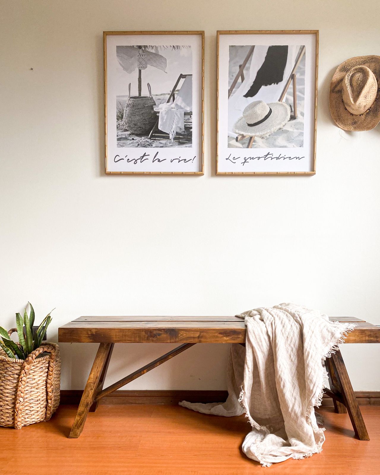 Wooden bench styled with cozy blanket and framed art in entryway Wooden bench styled with cozy blanket and framed art in entryway