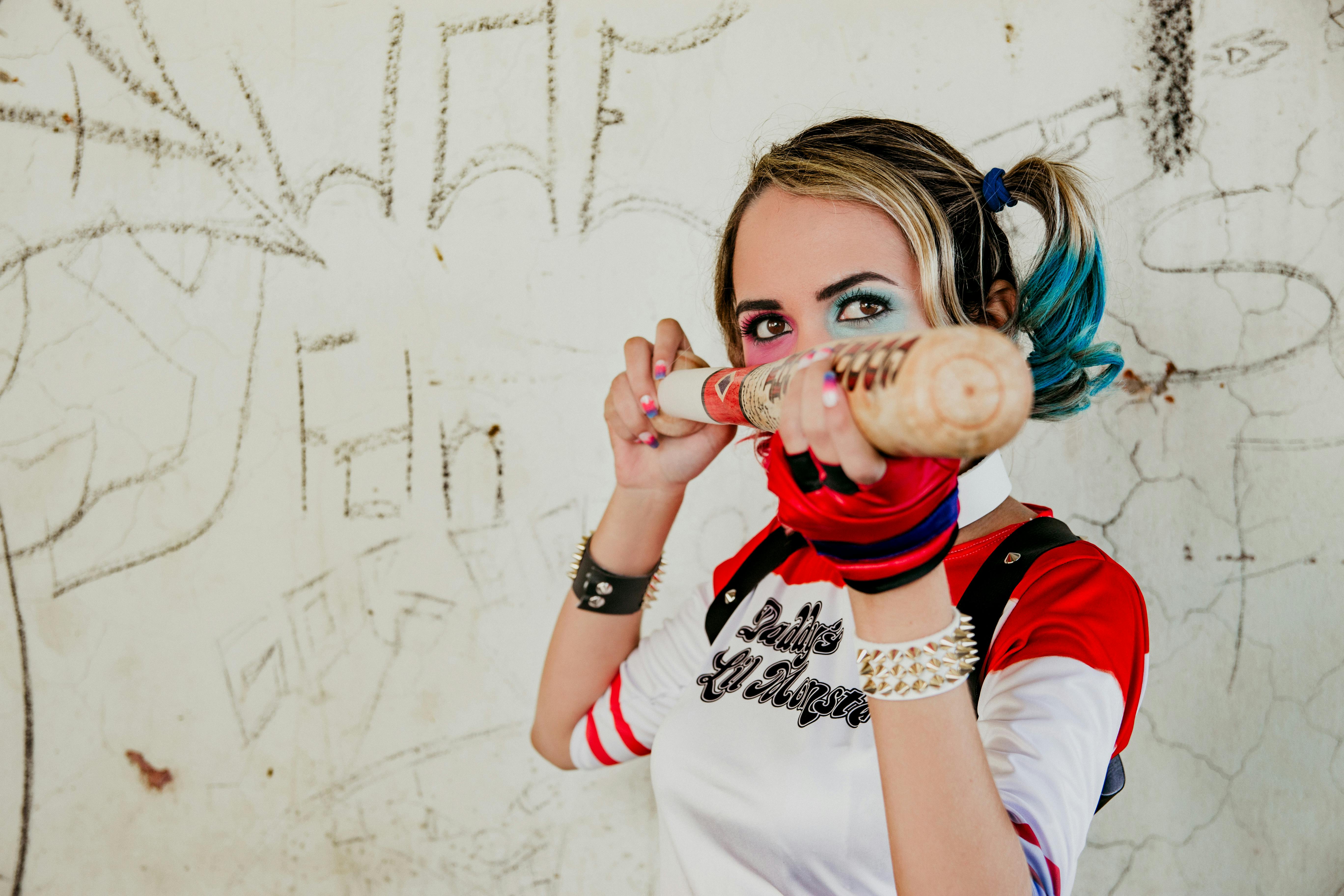 Vibrant cosplay photo of a woman in Harley Quinn inspired costume with baseball bat.