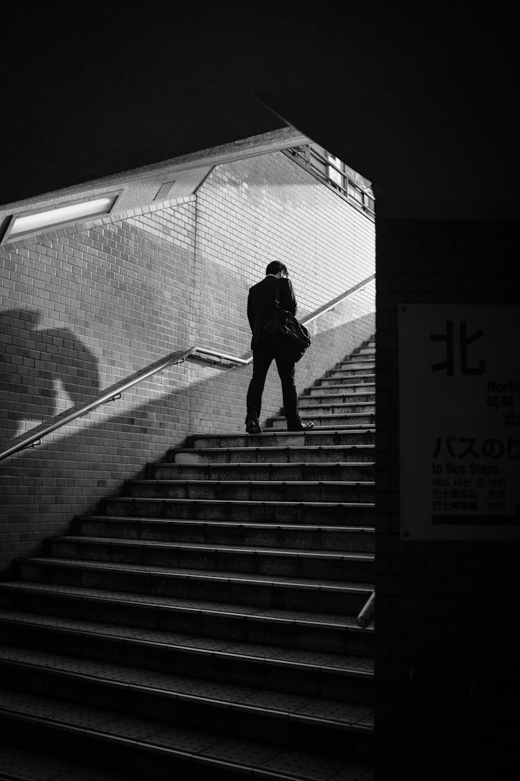 Man In Black Jacket Walking On Stairs