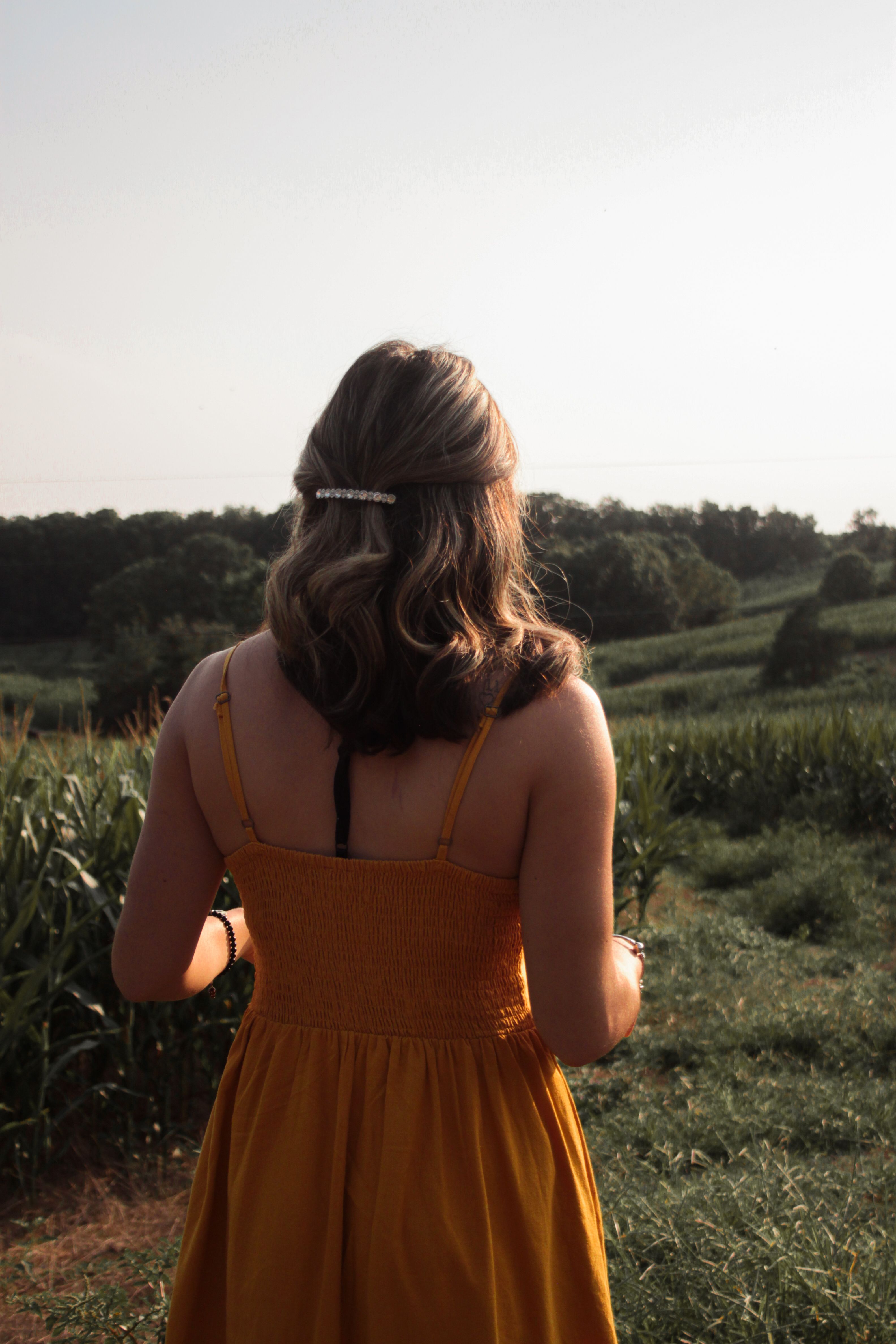 A Back View of a Woman in Yellow Dress Standing on the Field · Free ...