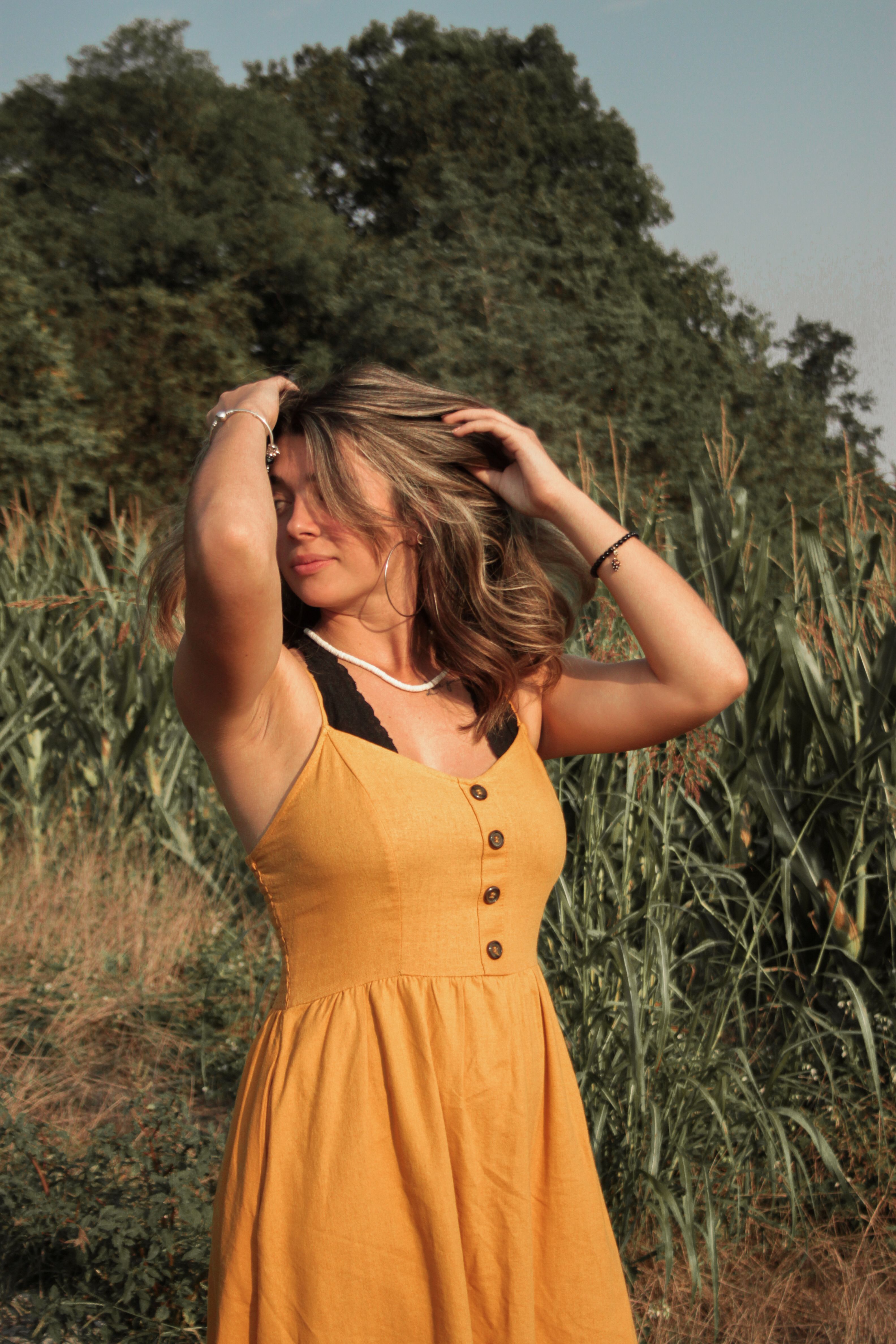 Woman in Yellow Dress Standing beside Tall Green Grass · Free Stock Photo