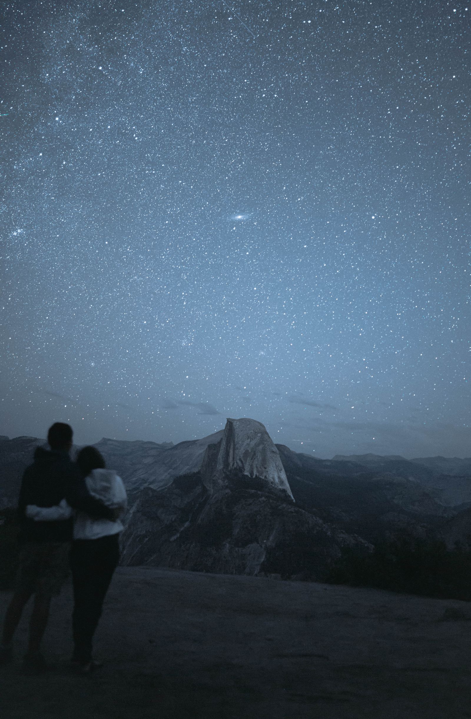Couple embracing while watching the starry night sky