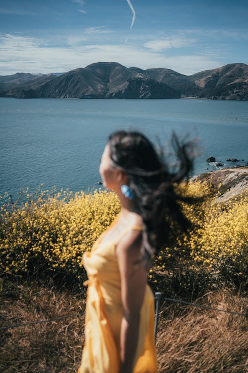 Woman in Yellow Dress on a Cliff near the Sea