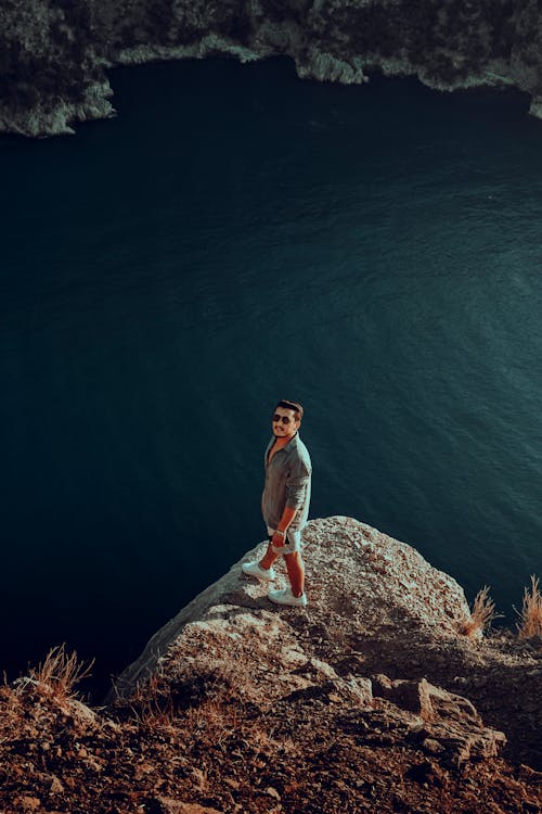 Man Standing on a Cliff and Looking at Camera