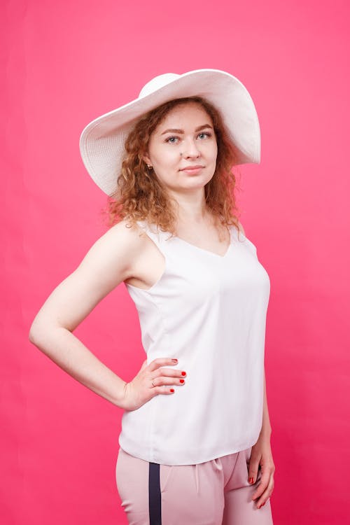 Woman in Pink Background with Hand on Chin