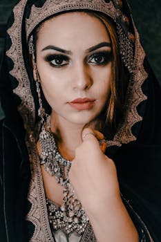 Close-up portrait of a woman in traditional clothing with striking eyes and intricate jewelry.