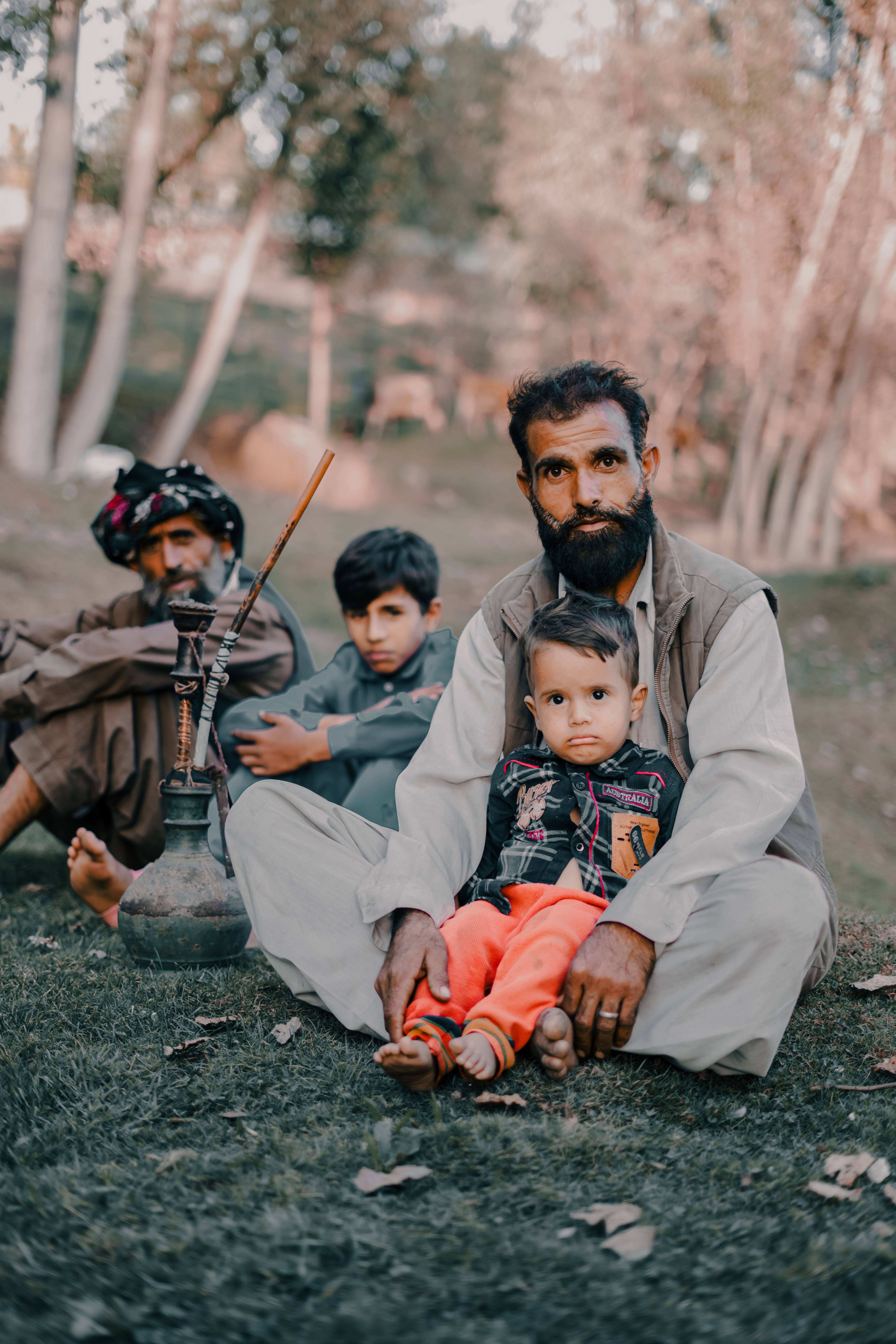 A family sitting together outdoors enjoying leisure time with a hookah pipe.