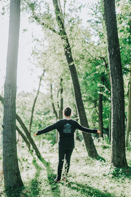 Free Woman in Black Long Sleeve Shirt Standing in the Woods Stock Photo