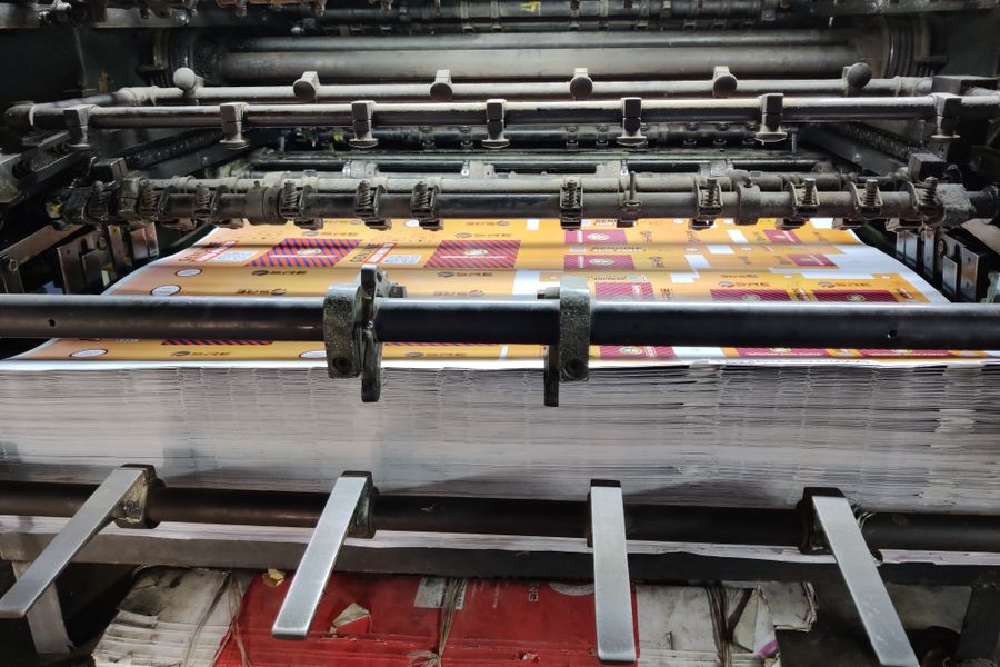 Industrial printing press feeding printed sheets