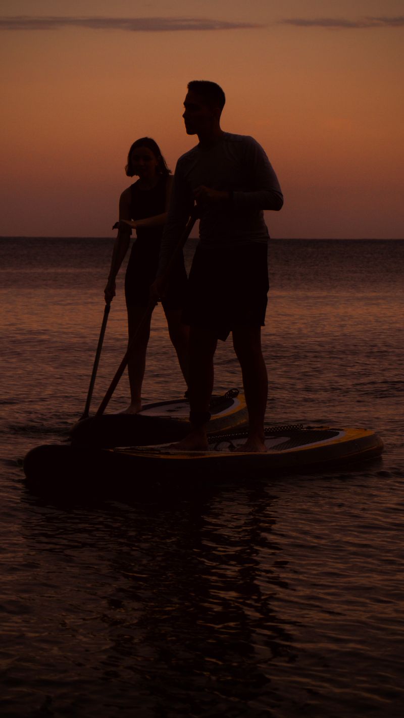 Pareja haciendo paddle surf al atardecer en la Sunset Experience, cerca de Salou