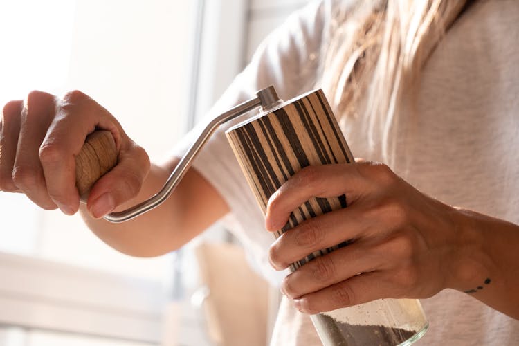 A Person Using A Salt And Pepper Grinder