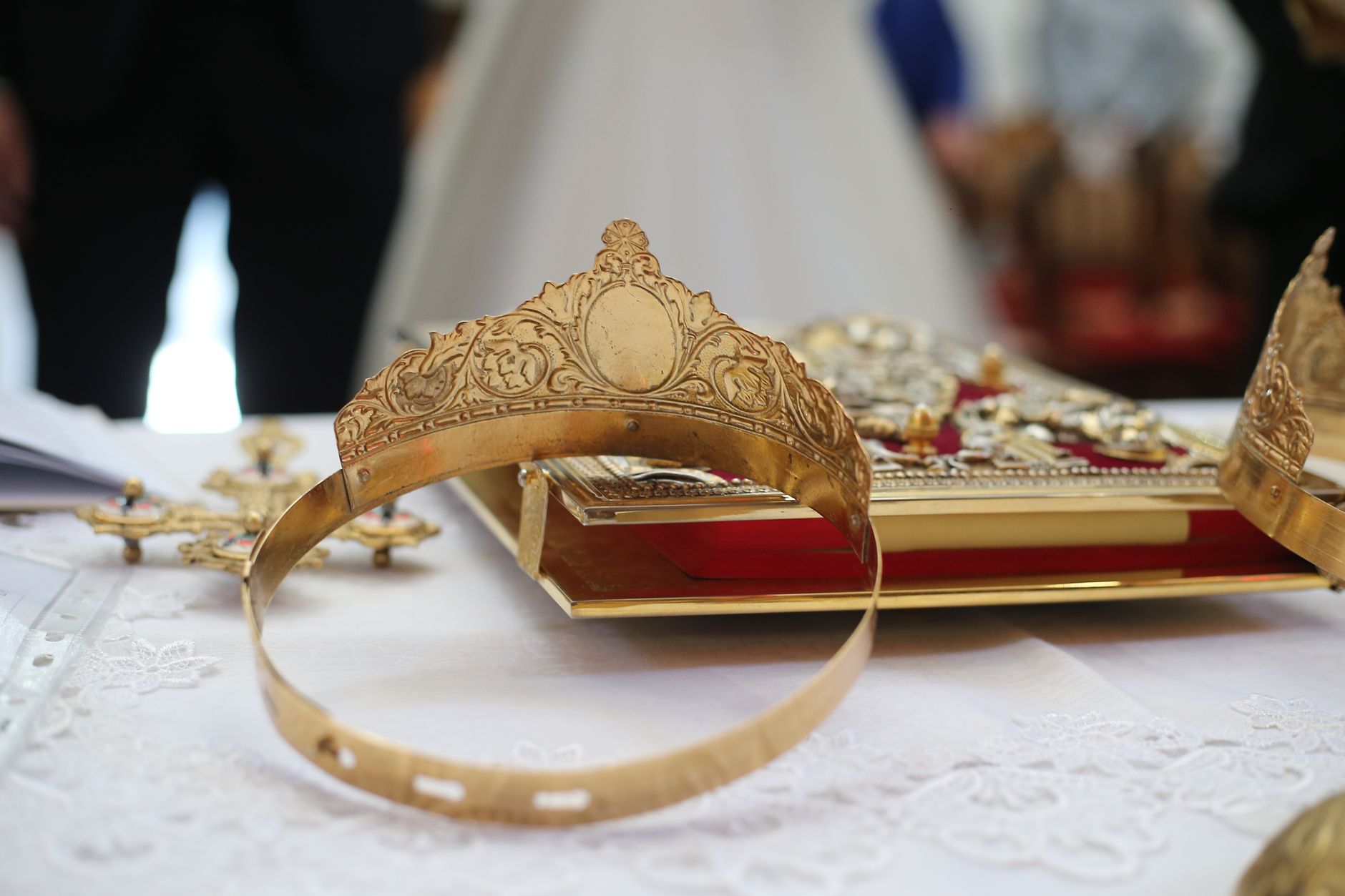 Close-up of ornate golden crowns on a church altar table, symbolizing marriage traditions.