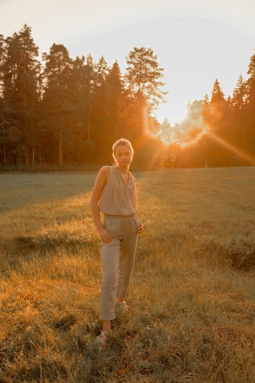 A Woman Standing on Green Grass Field