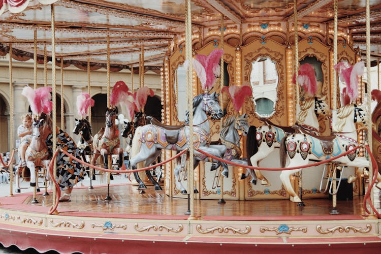 A Child Riding A Carousel