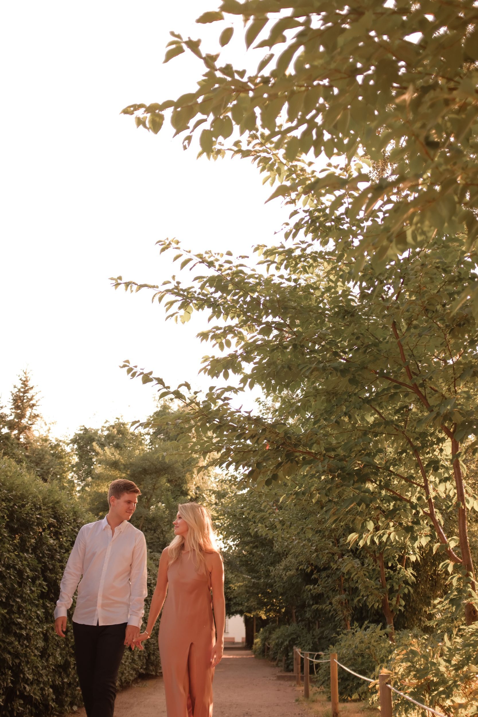 A Couple Walking Hand in Hand on a Pathway Between Green Trees · Free ...