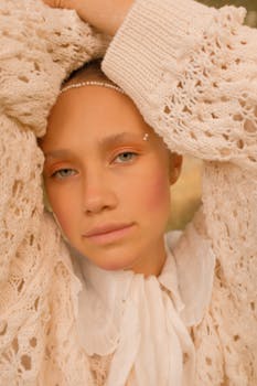 Close-up portrait of a woman in a lace sweater, exuding serenity and style.