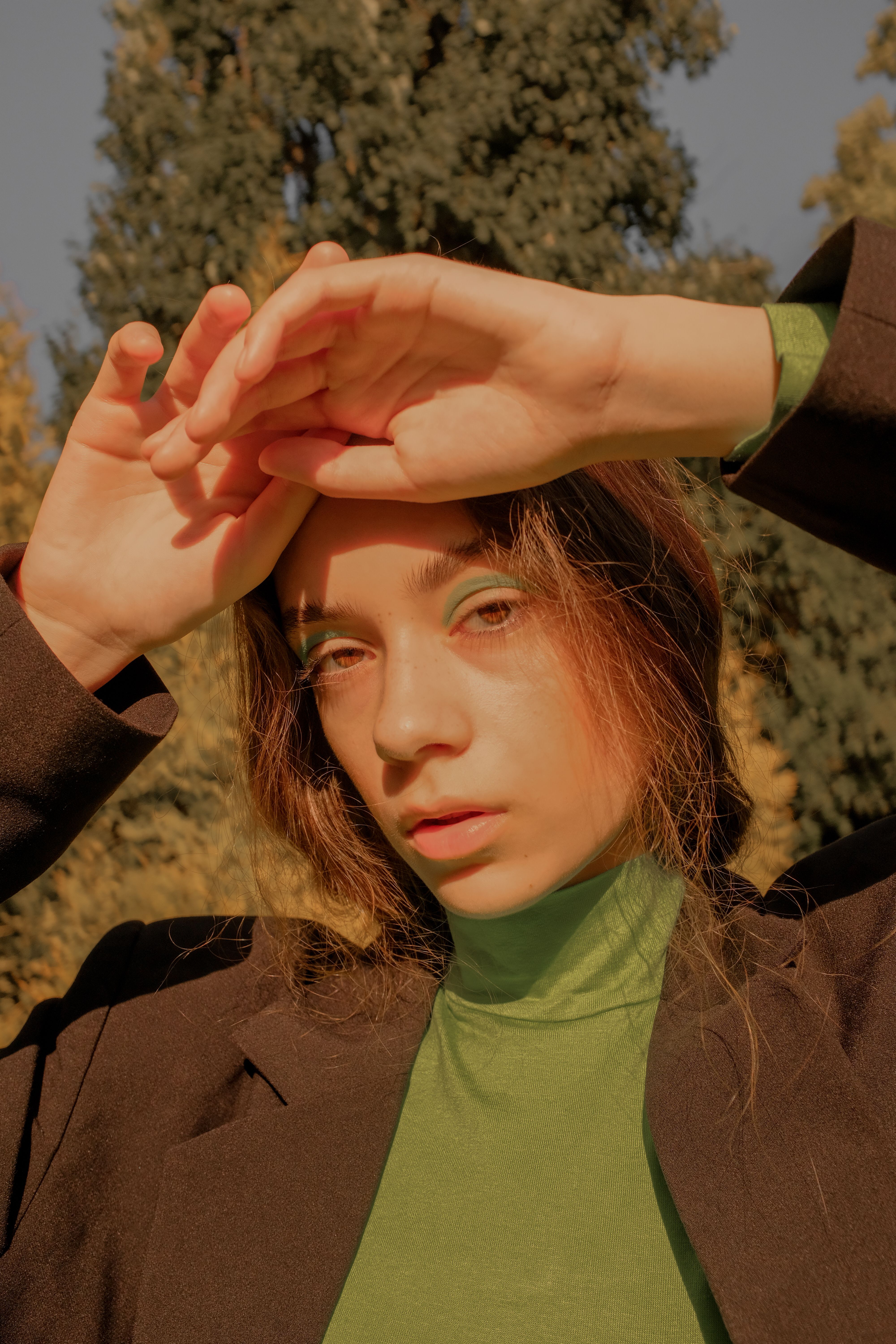 Woman wearing a dark green turtleneck with a velvet blazer
