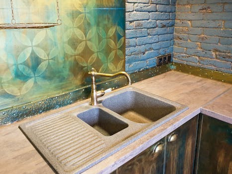 Cozy kitchen interior featuring a rustic double sink, decorative brick wall, and vibrant backsplash.