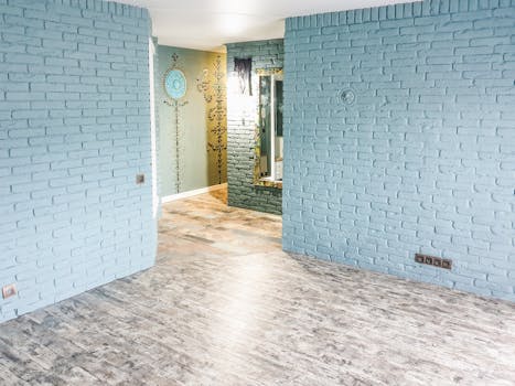 Bright modern apartment featuring blue brick walls and wooden flooring.