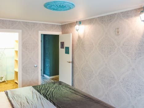 A bright and modern bedroom showcasing elegant wallpaper and sleek decor elements.