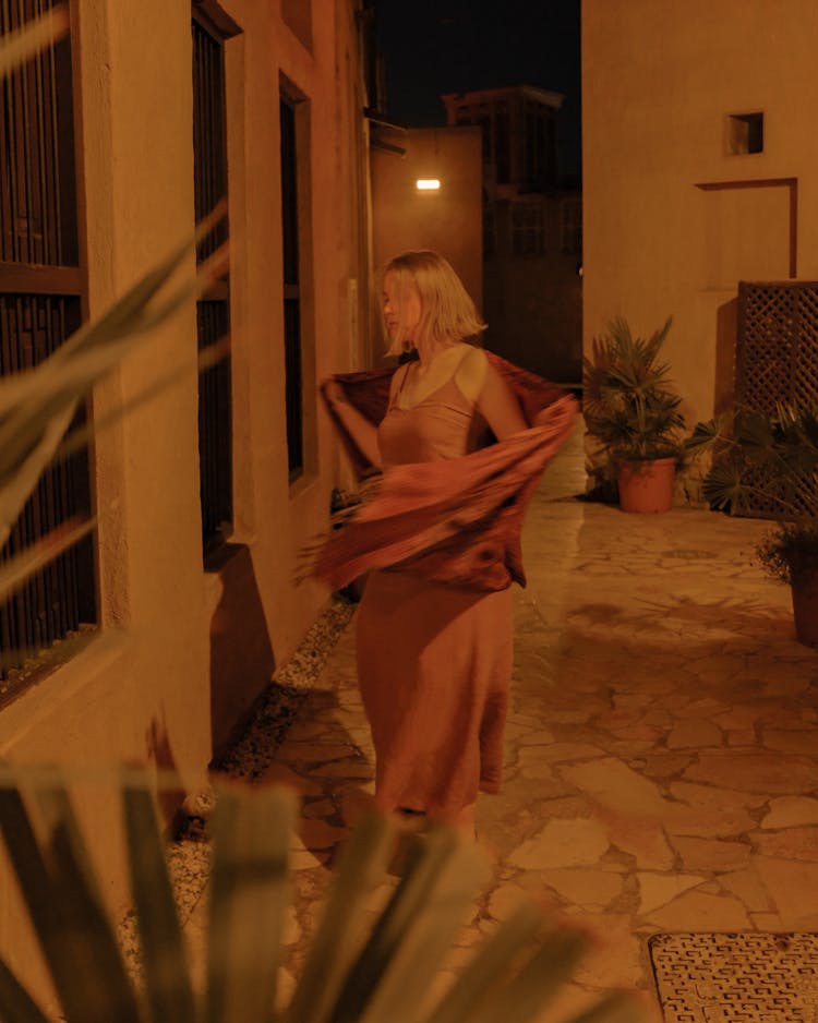 Woman In Pink Dress Removing Scarf