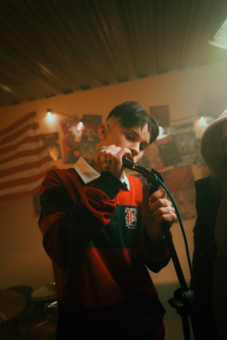 Man In Black And Red Jacket Holding Microphone